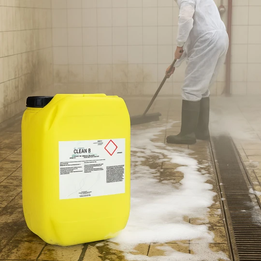 czyszczenie przemyslowego pomieszczenia kafelkowego srodkiem CLEAN B-83 25kg, mezczyzna w ubraniu roboczym szoruje podloge, pojemnik na pierwszym planie