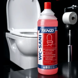 Butelka profesjonalnego płynu do czyszczenia toalet TENZI WC Sani o pojemności 1 litra stoi w łazience przed lśniącą, czystą toaletą, co ukazuje skuteczność działania produktu.